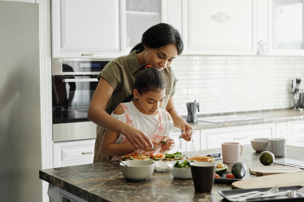 services-01 A mom and daughter share a bonding moment while preparing a healthy lunch together in the kitchen.