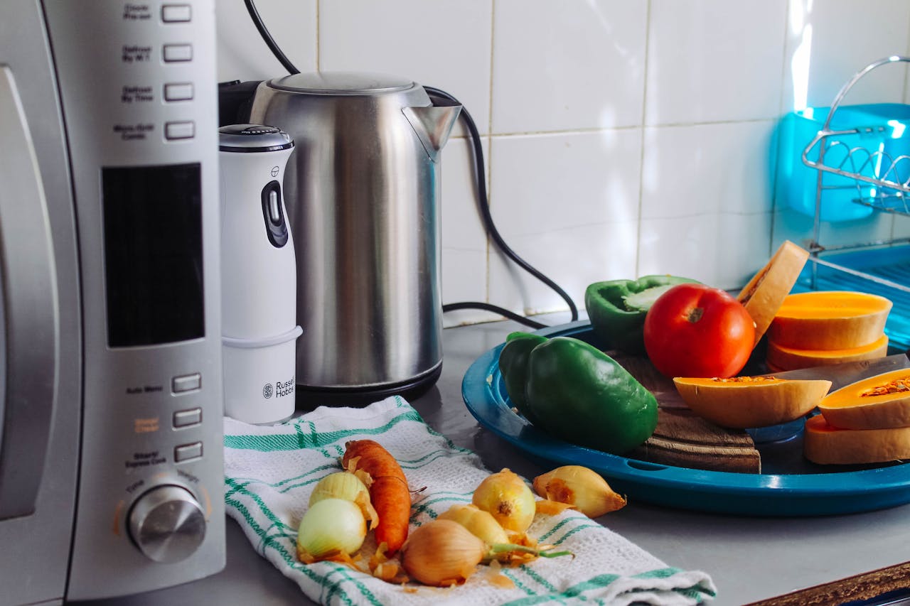 hero-homepage A modern home kitchen counter displaying fresh vegetables and appliances, ideal for healthy cooking.